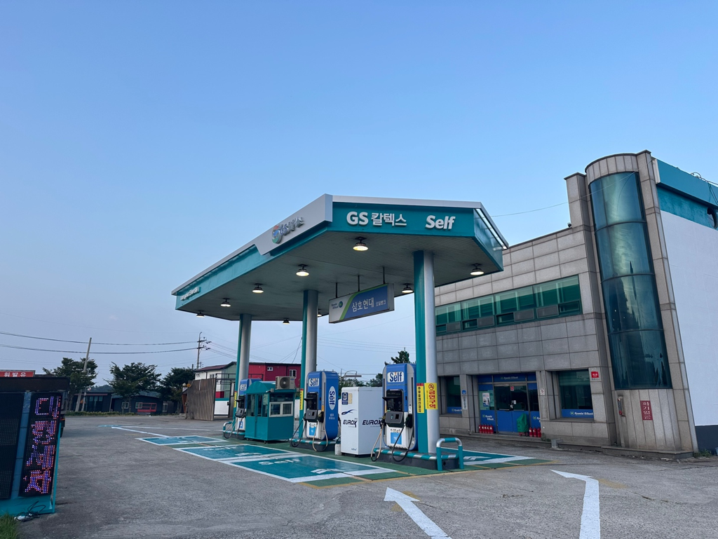 #6 · 평균 87.5 (gemini 84.0 / gpt 91.0)
gemini-pro: 전형적인 국도변 주유소의 기본 구조와 부속 건물이 매우 선명하게 나타납니다. / gpt: 소규모 셀프주유소의 캐노피, 주유기와 진행 방향 표시가 또렷하지만 도로 측 연결은 프레임 밖이다.